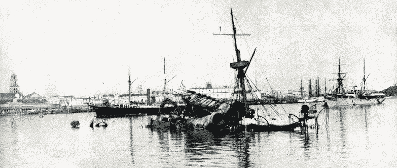 USS Maine partially submerged in Havana harbor, empty-masted sailing ships moored nearby.