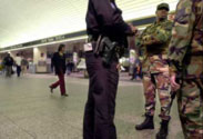 Armed, fatigue-wearing military guards standing around at Penn Station
