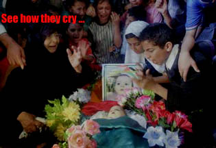 The caption says - 'See how they cry...' Photo shows a group of young Palestinian children crying bitterly as they stand over the dead body of the baby. A photo of the baby, when he was alive, is resting above his head.