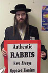 photo of an orthodox Jewish man holding a sign which reads - ‘Authentic RABBIS have always opposed Zionism’